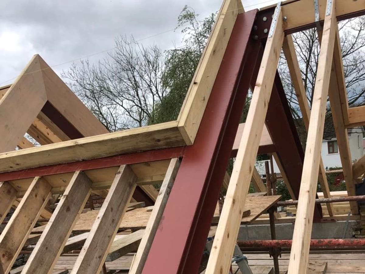 Roof trusses and steel beams under construction with wooden framework