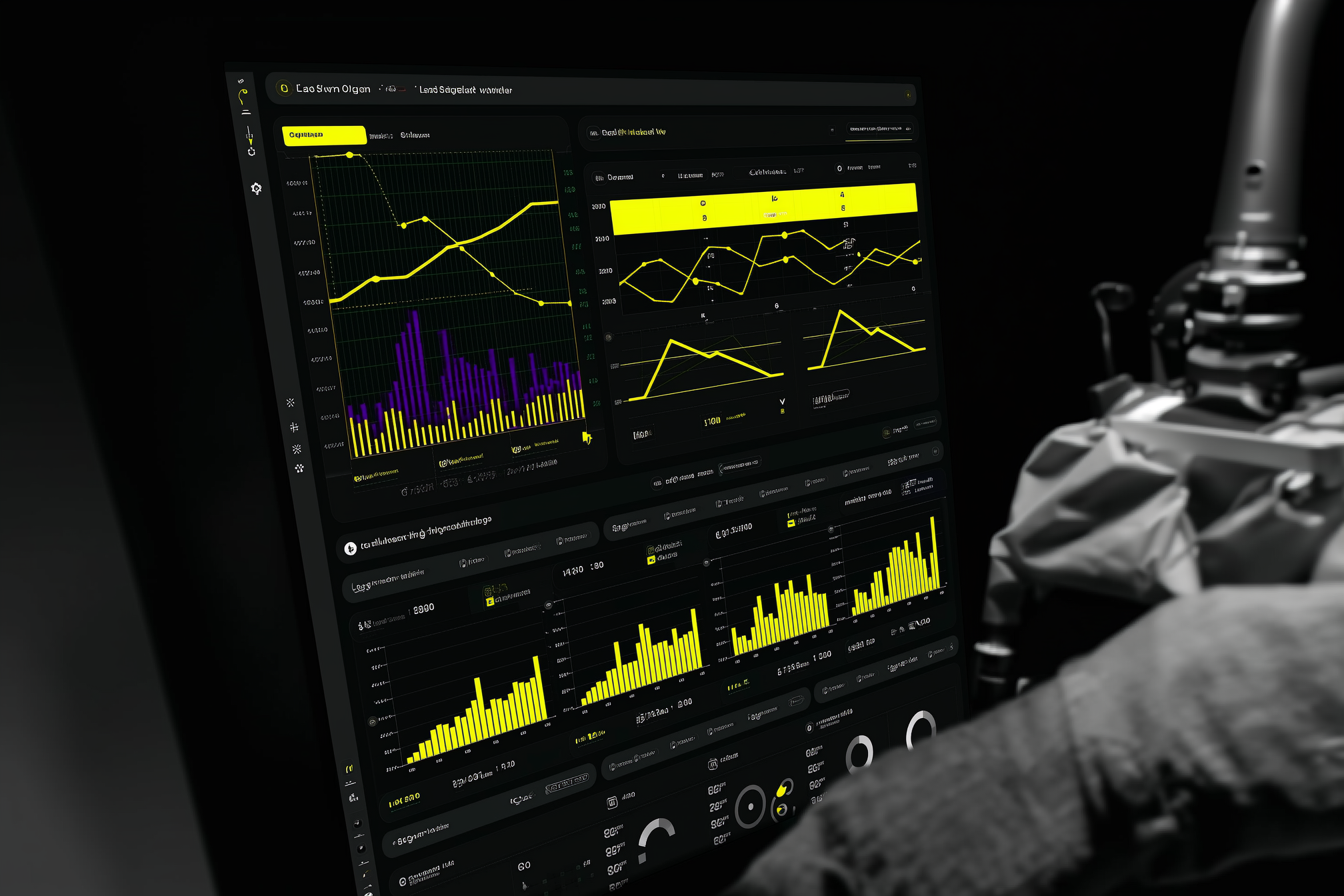 Person viewing dark analytics dashboard with yellow line graphs and bar charts on monitor