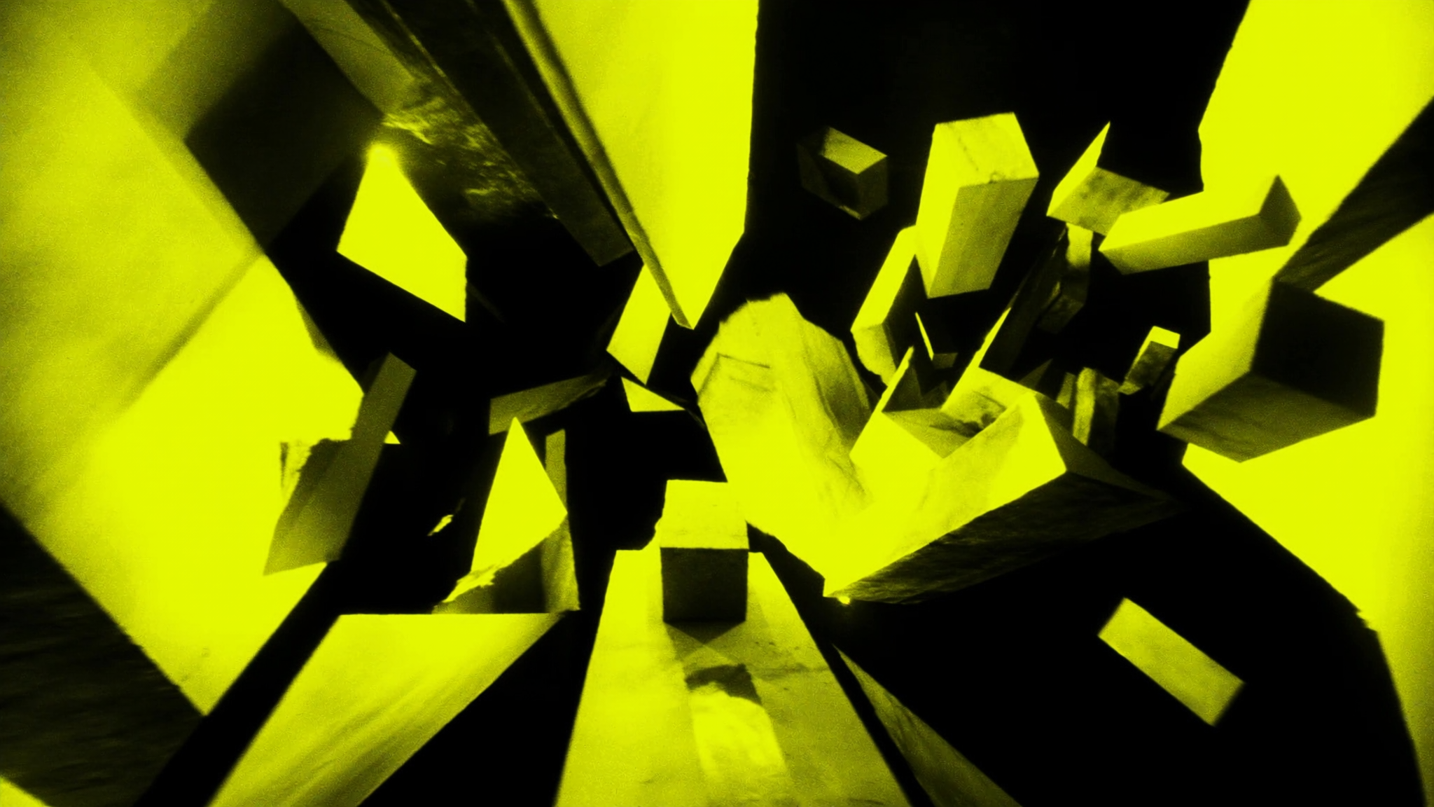 Three-dimensional geometric shapes in bright yellow and black with dramatic lighting and shadows