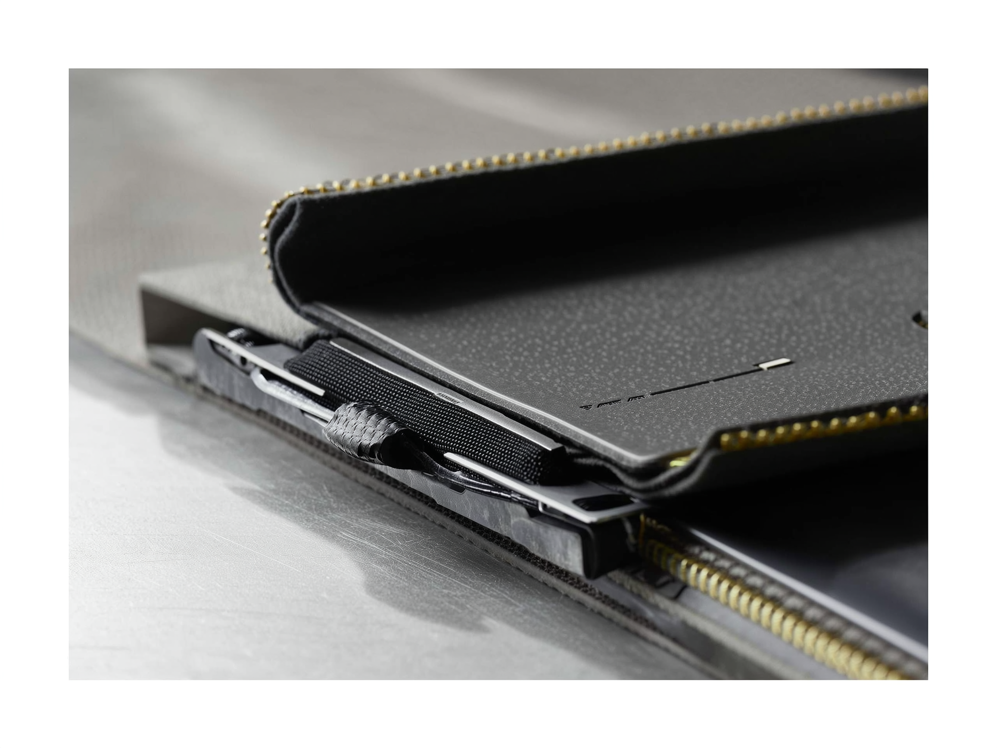 Black wallet with gold zipper detail and pen inside, close-up view