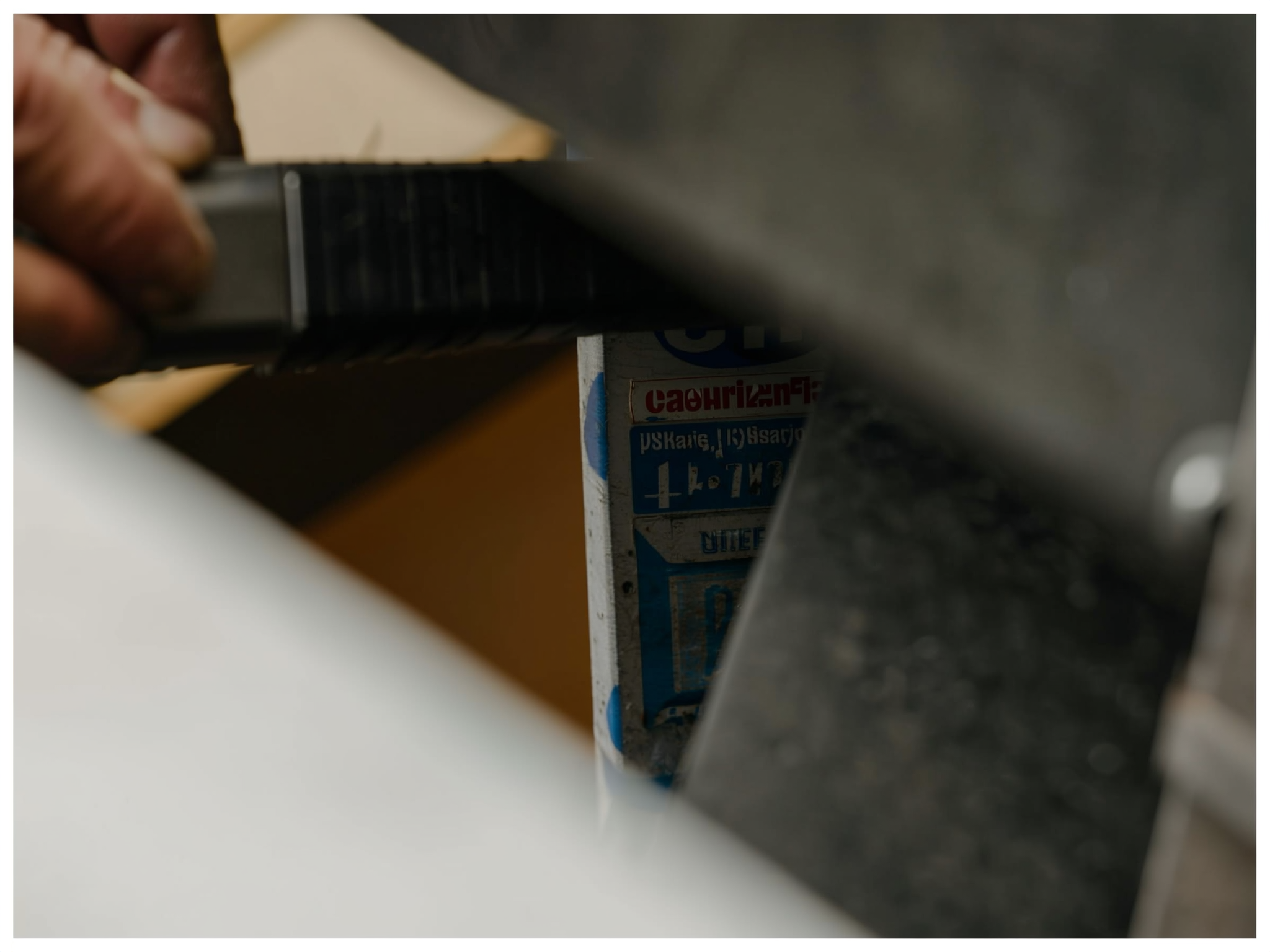 Person applying dark paint or coating to a surface with a brush