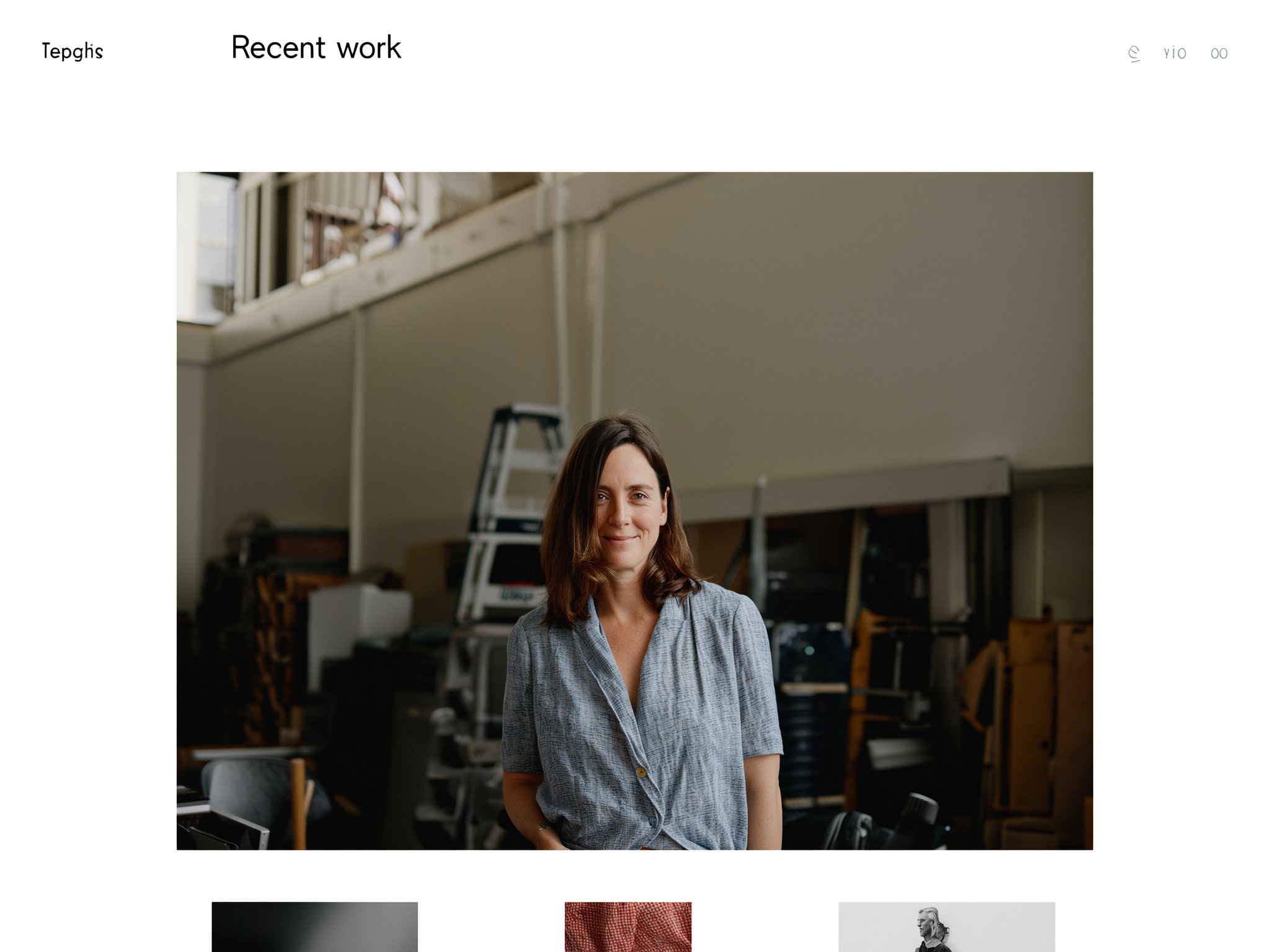 Woman in gray shirt standing in warehouse or industrial workspace with equipment visible