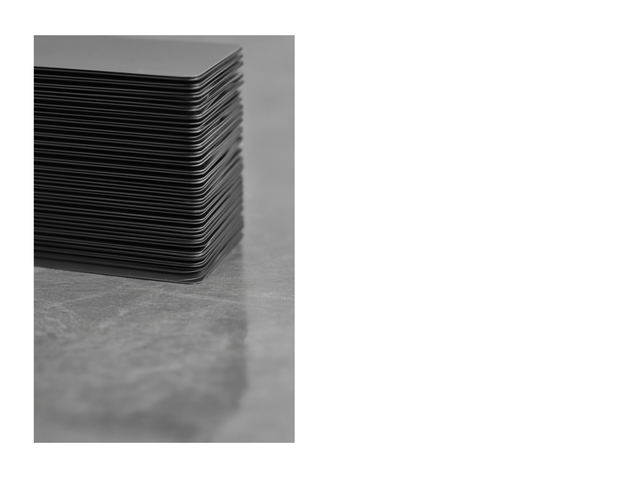 Stack of black plastic cases or trays arranged in a neat pile